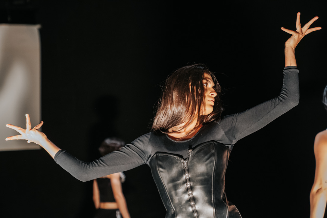 One female dancer wearing all black. Looking to right top corner.